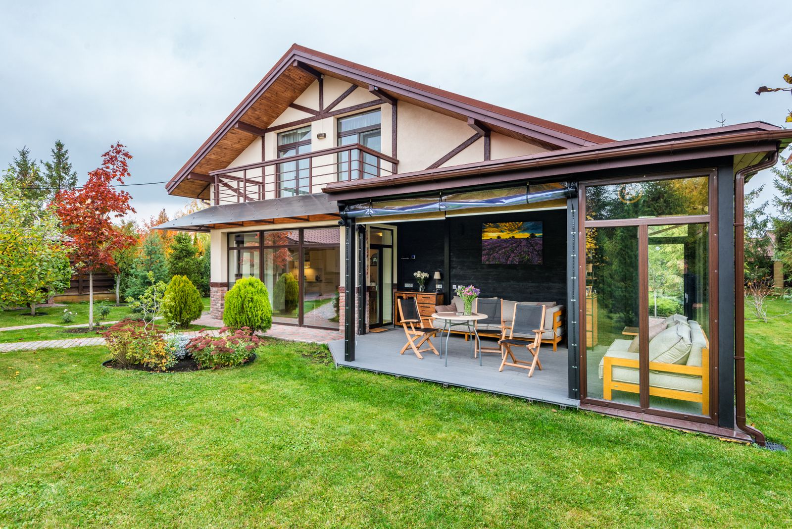 Extension vitrée en bois et métal sur une maison existante