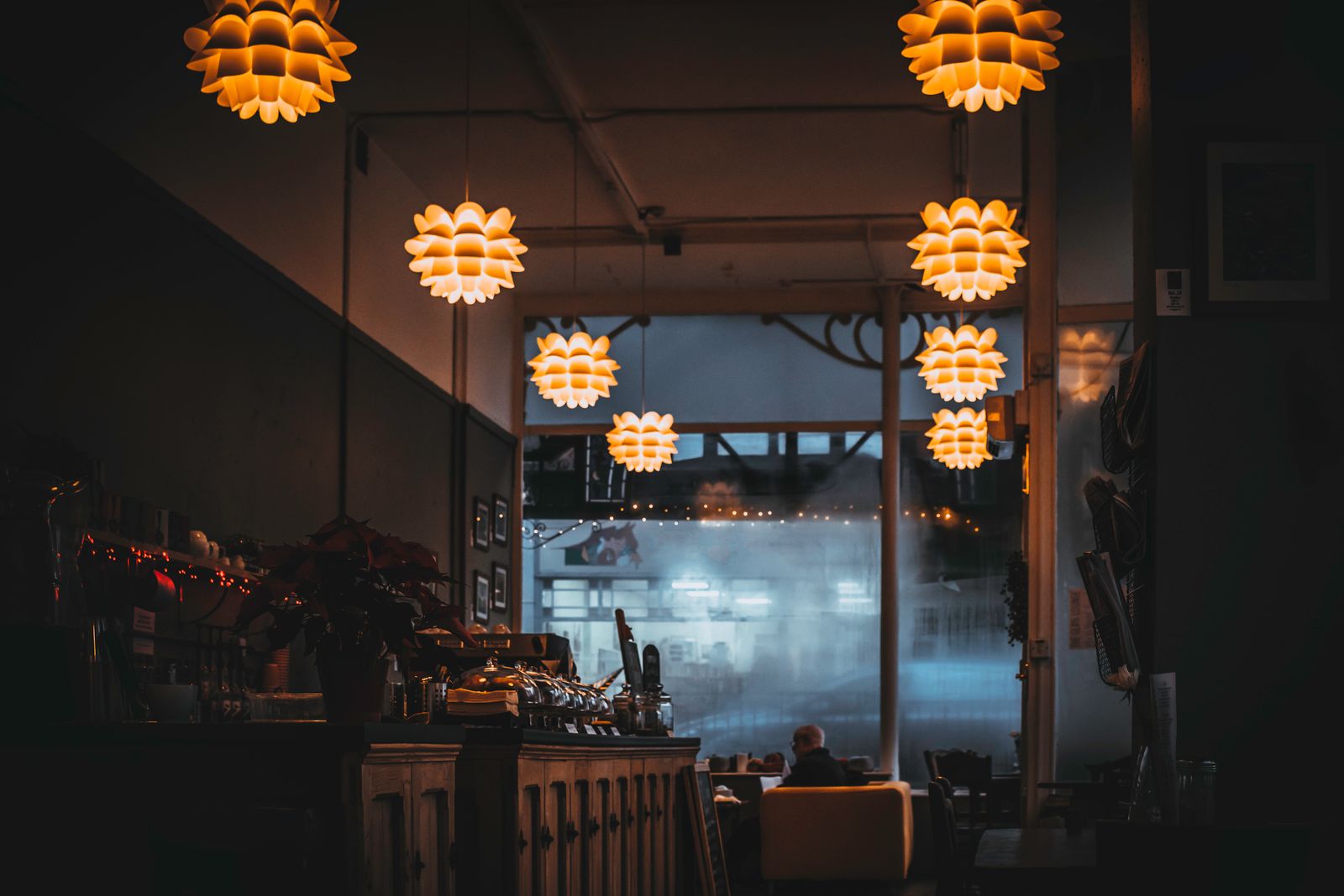Le comptoir du bar dans une lumière tamisée, bouteilles en étagère