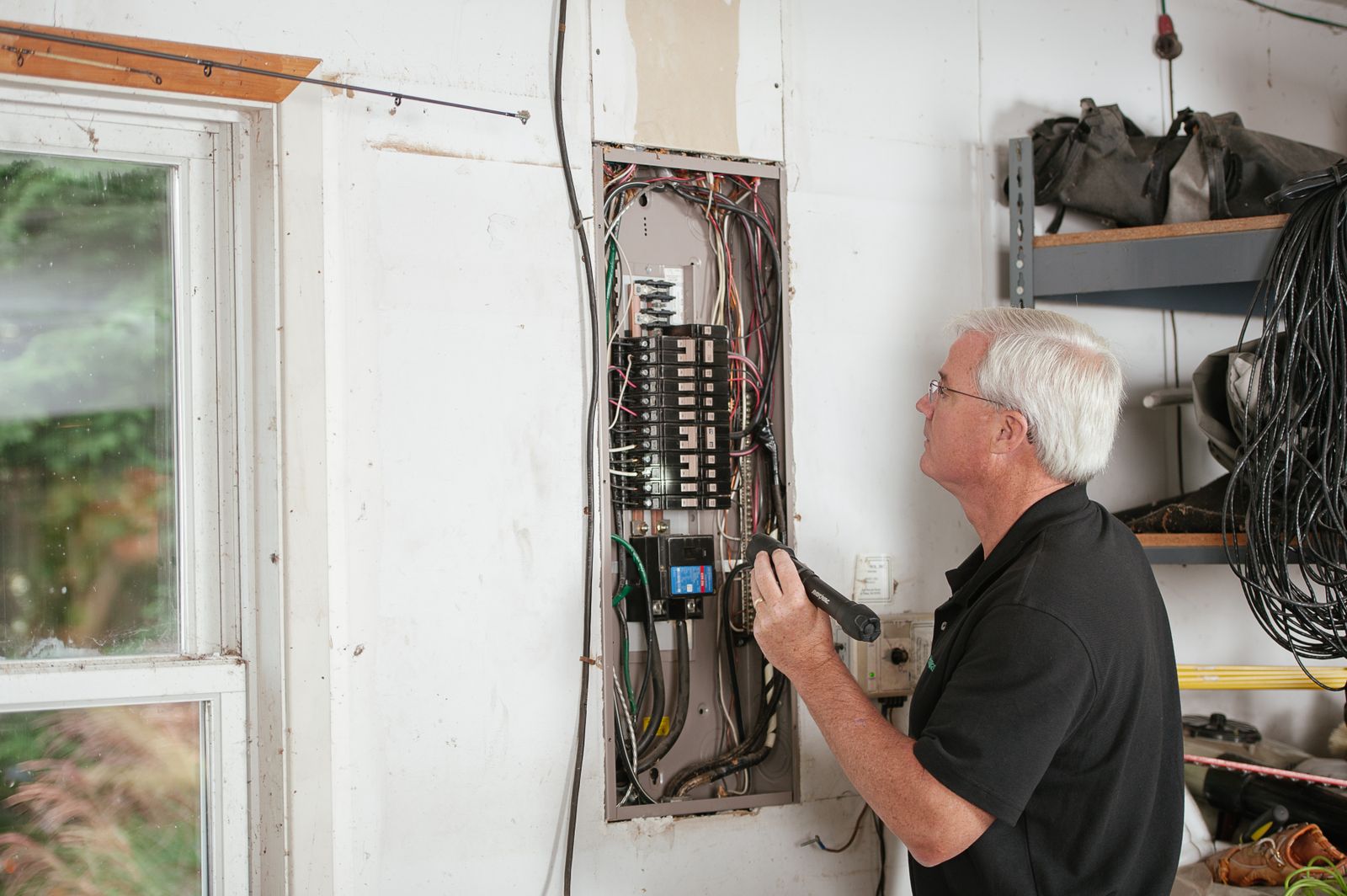 Électricien devant un tableau électrique dans un garage