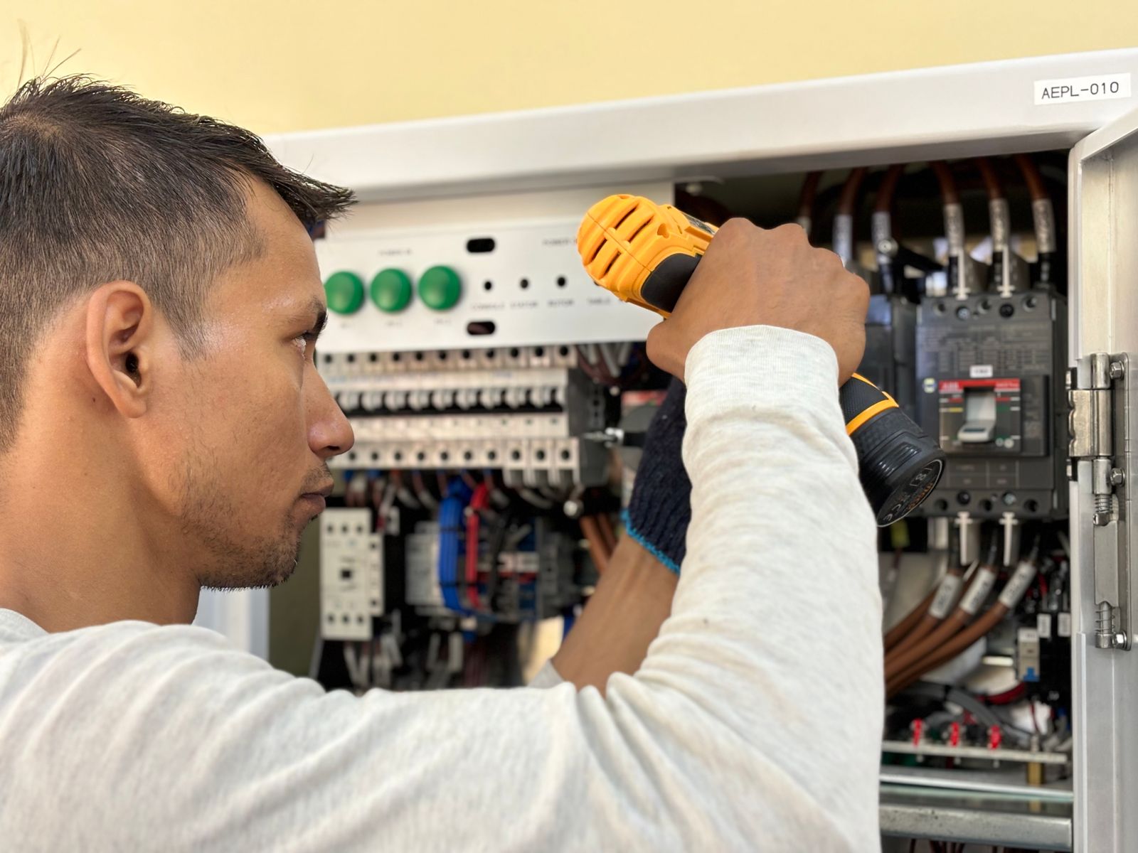 Électricien reprenant le câblage d'un tableau électrique