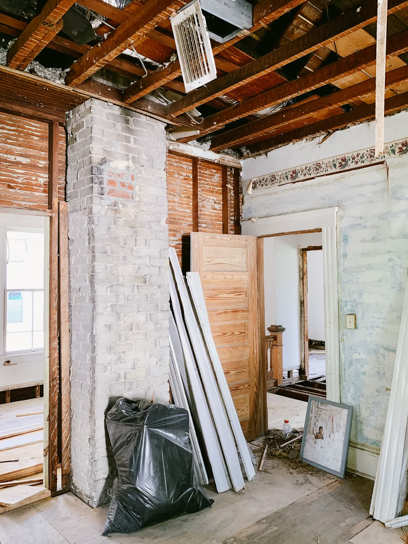 Intérieur de maison ancienne en cours de rénovation, brique et charpente apparentes