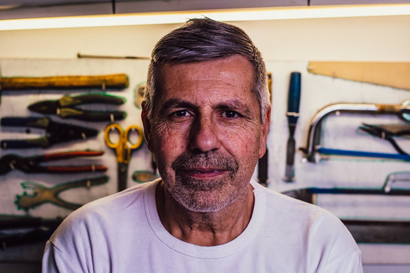 Julien Larroque dans son atelier, devant son tableau d'outils