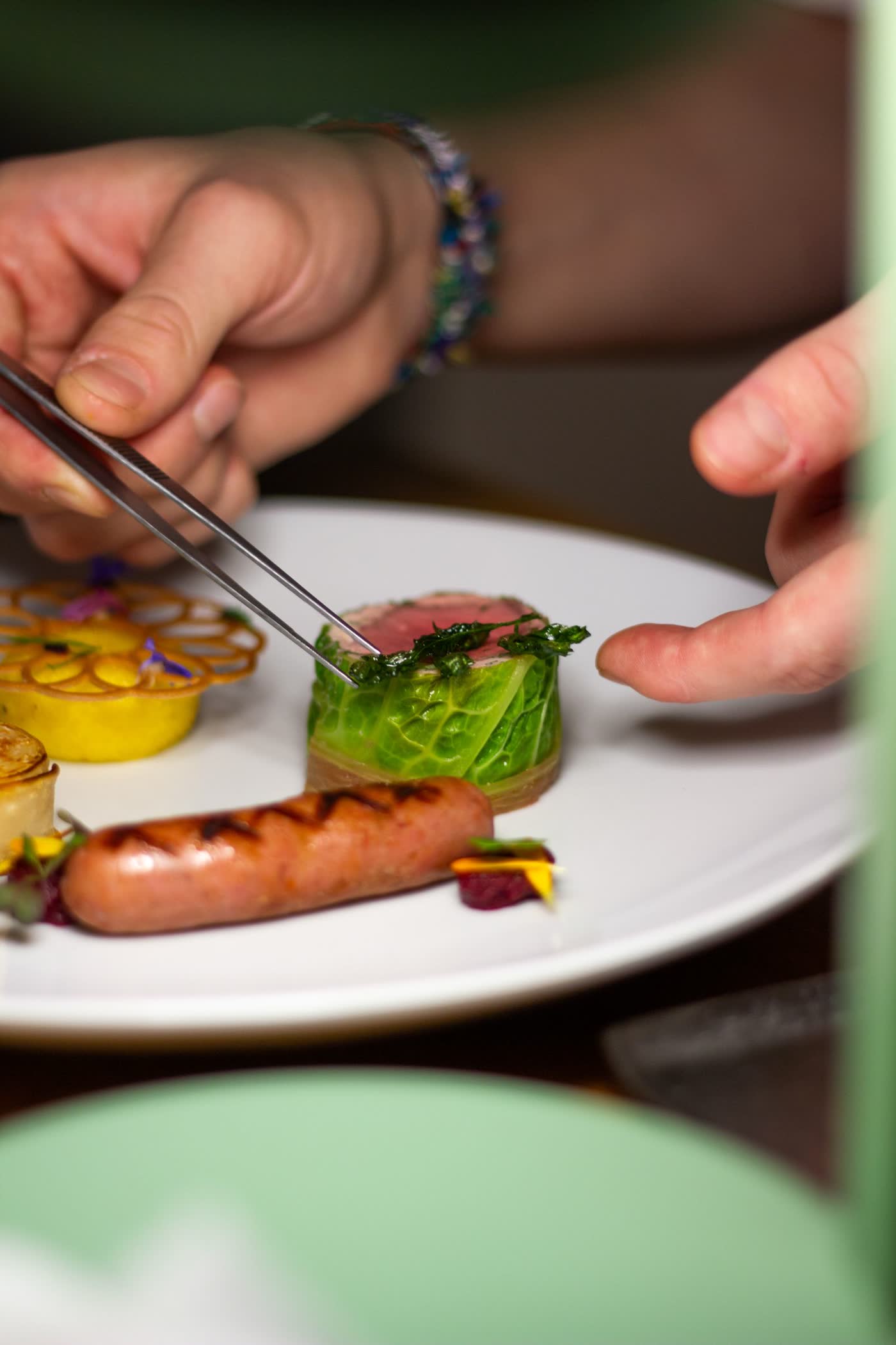 Mains du chef dressant une assiette